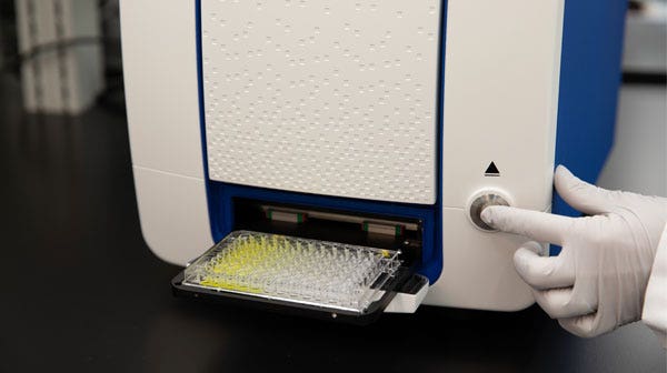 SpectraMax Mini, Main appuyant sur le bouton d’éjection